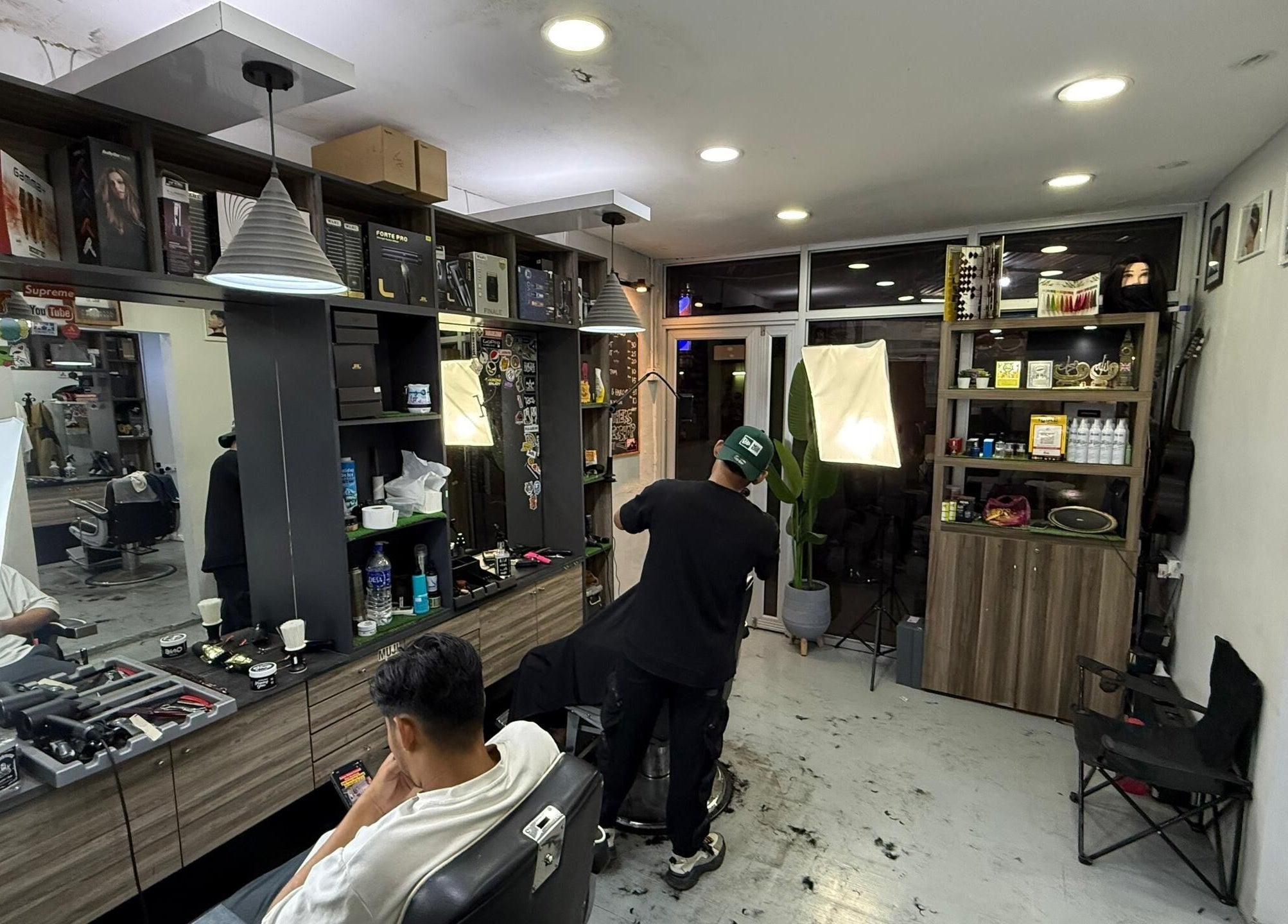 Interior of Brothers Barbershop Tiram with stylist at work in Ulu Tiram, Johor, MY.