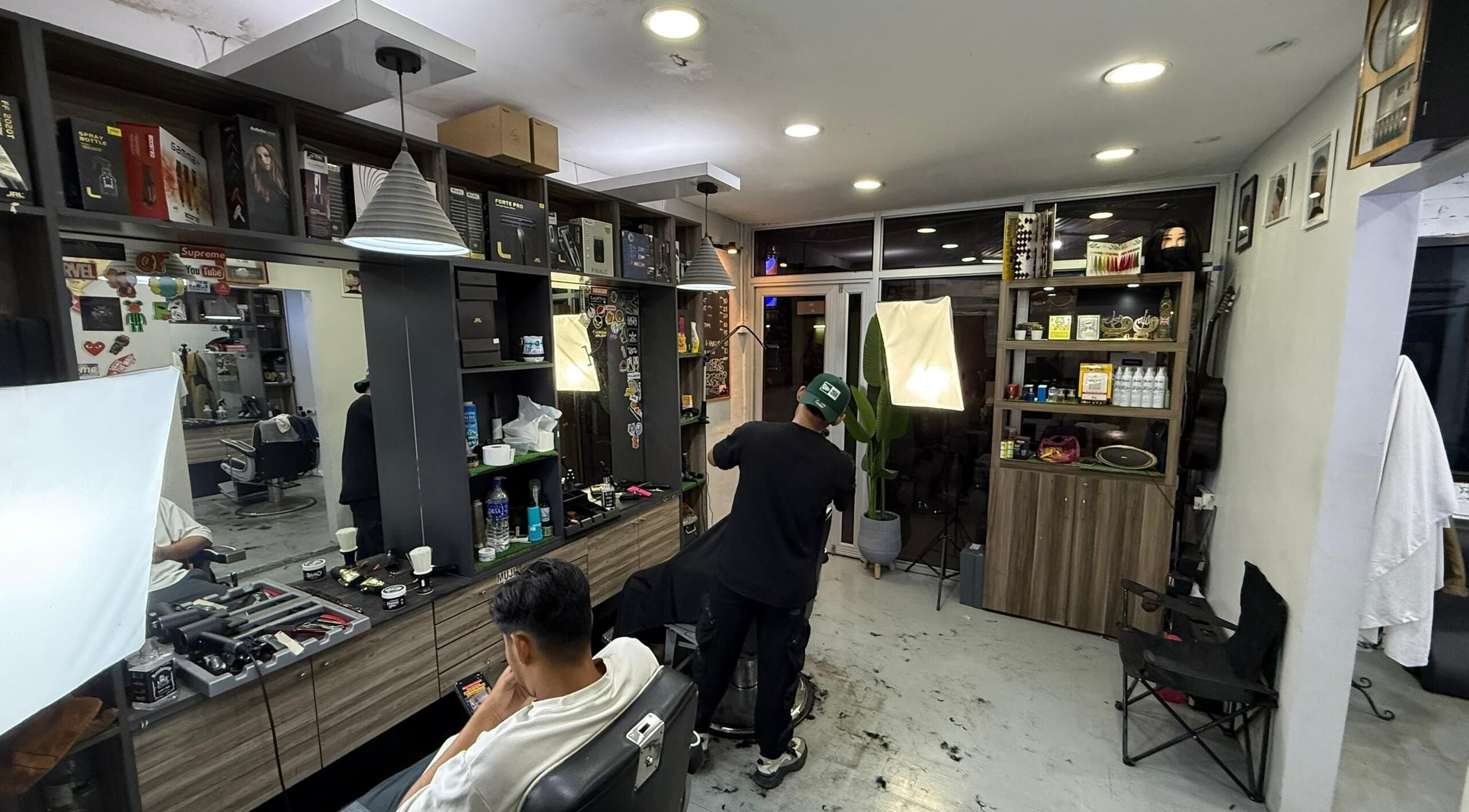 Interior of Brothers Barbershop Tiram with stylist at work in Ulu Tiram, Johor, MY.