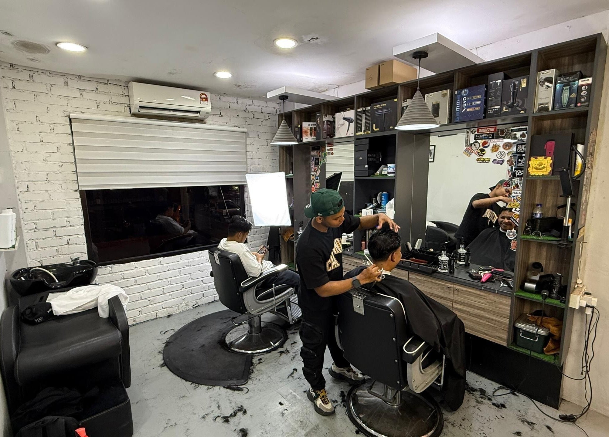 Barber styling a customer's hair at Brothers Barbershop Tiram, Ulu Tiram, Johor, MY.