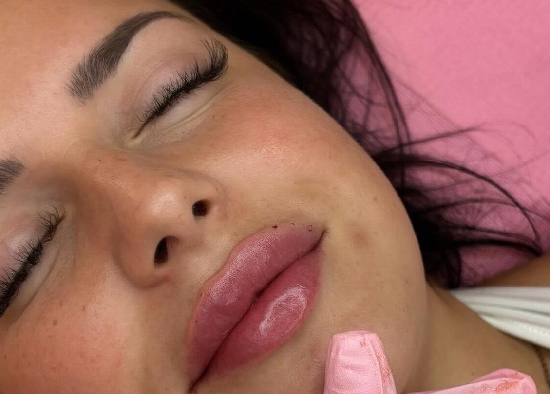 Relaxed woman with plush lips and perfect brows at MK Aesthetics and Beauty Clinic, Birmingham, England, GB.