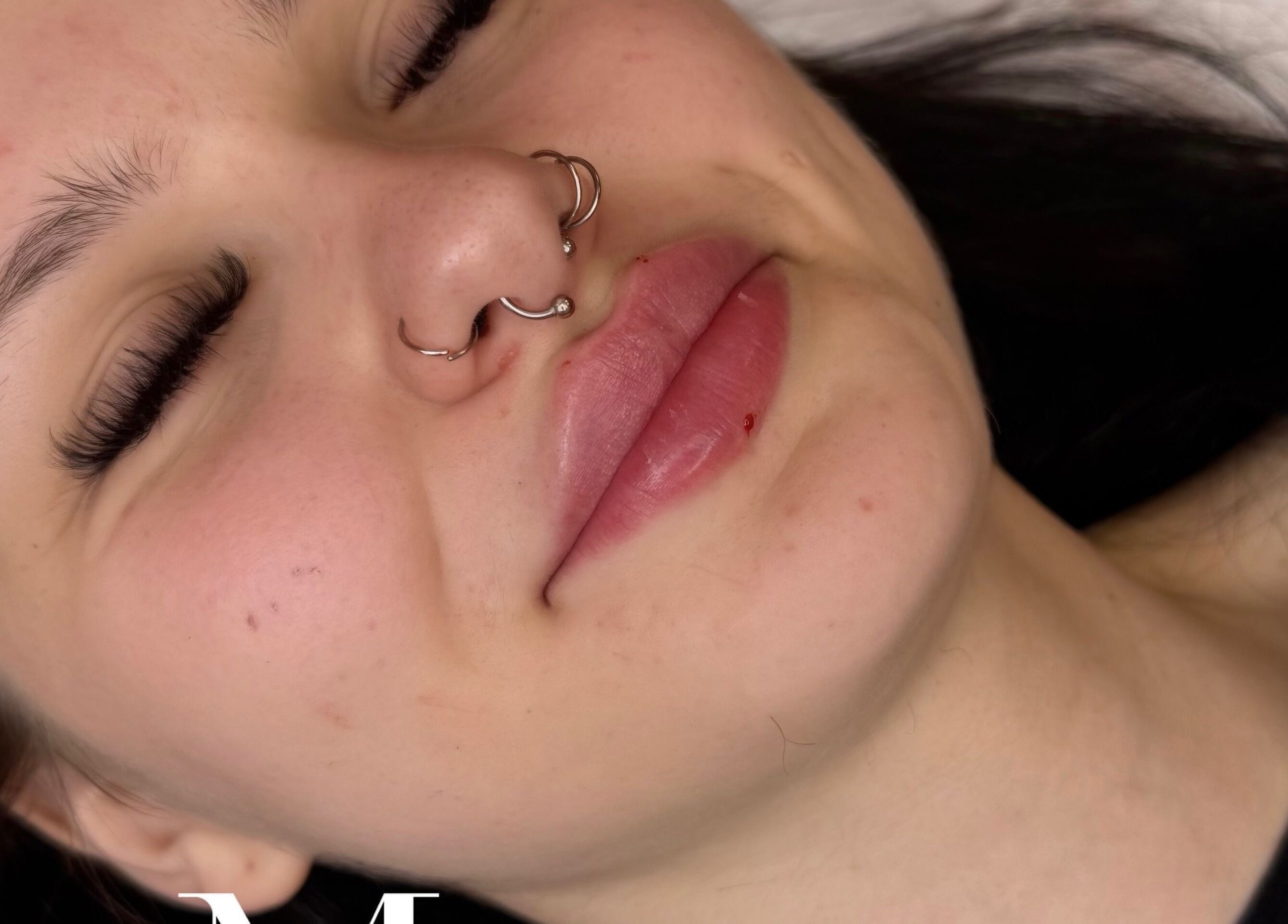 Close-up of a relaxed face with piercings at MK Aesthetics and Beauty Clinic, Birmingham, England, GB.