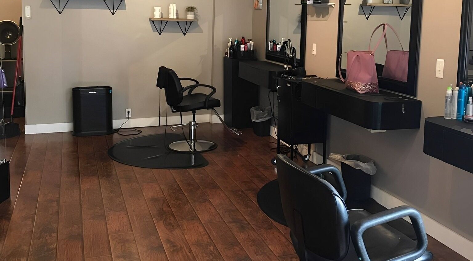 Modern salon interior at Scissor Excitement, Hampden, Maine, US with stylish chairs and shelving.