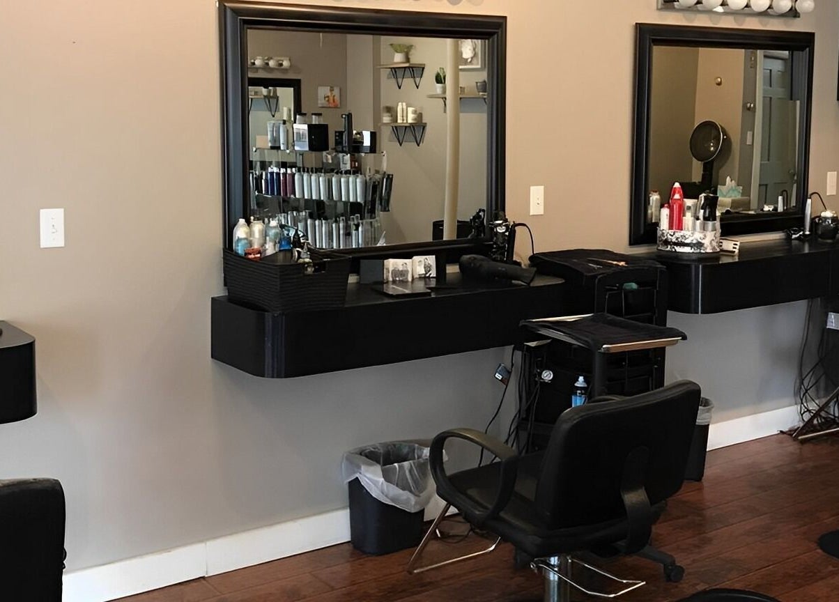 Stylish interior of Scissor Excitement salon in Hampden, Maine, US with modern black styling stations.