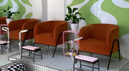 Zona de espera moderna en Espacio 216, Quilicura, Región Metropolitana, CL con sillones naranjas y plantas.