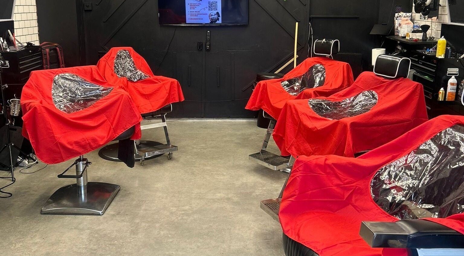 Barber Stop's sleek interior showcases red-covered chairs in Birmingham, England, GB.