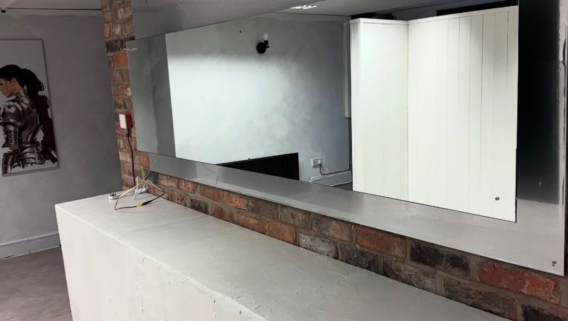 Modern wall mirror at Demi The Hairdresser, Manchester, England, GB showcasing sleek salon design.