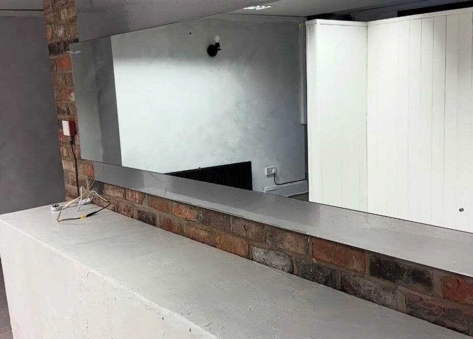 Modern wall mirror at Demi The Hairdresser, Manchester, England, GB showcasing sleek salon design.