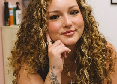 Smiling woman with curly hair at Xo Beauty, North Wales, Pennsylvania, US.