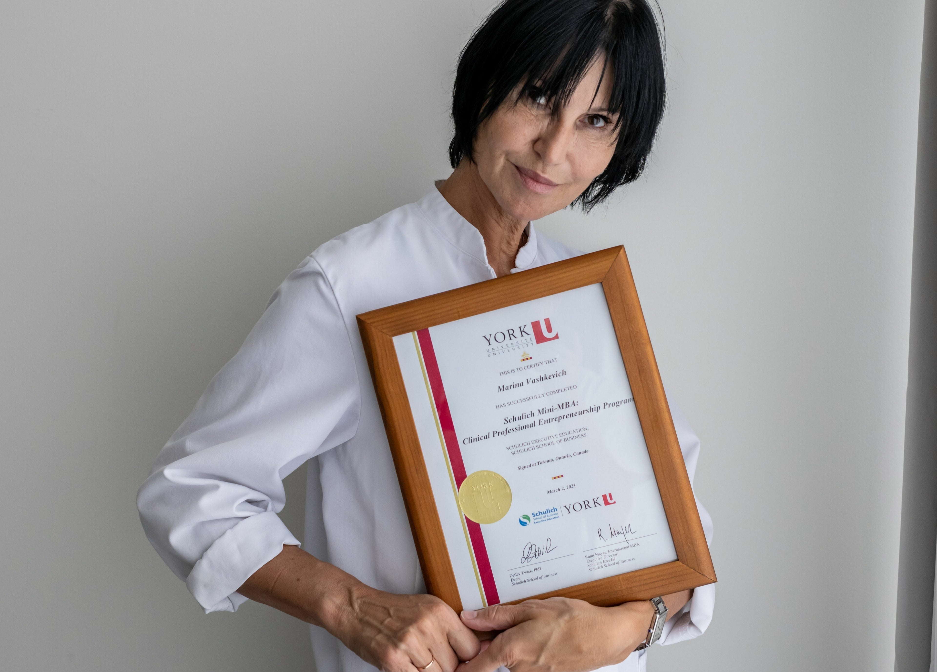 MedVSpa professional in Toronto, Ontario, CA holding a certificate, showcasing expertise and dedication.