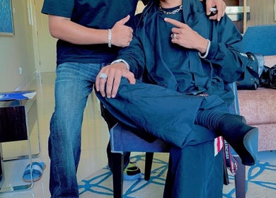 Friendly atmosphere at Pitstop Barbers, Dubai, AE, showcasing stylish attire and accessories.