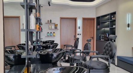 Modern interior of Pitstop Barbers in Dubai, AE featuring sleek black chairs and styling stations.