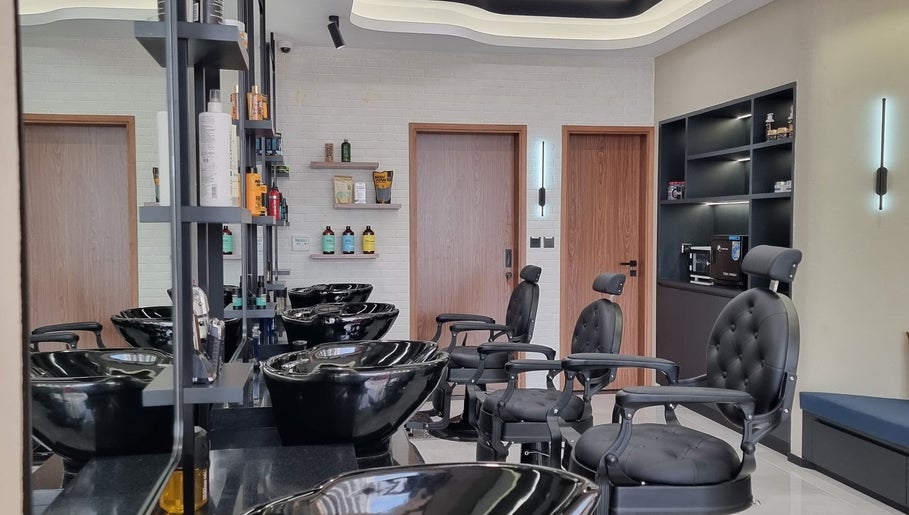 Inside Pitstop Barbers, Dubai, AE: sleek chairs, shampoo stations, and grooming products on display.
