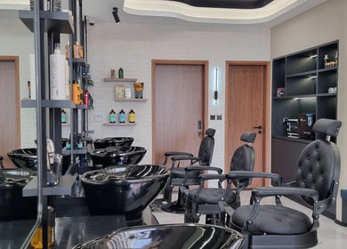 Inside Pitstop Barbers, Dubai, AE: sleek chairs, shampoo stations, and grooming products on display.