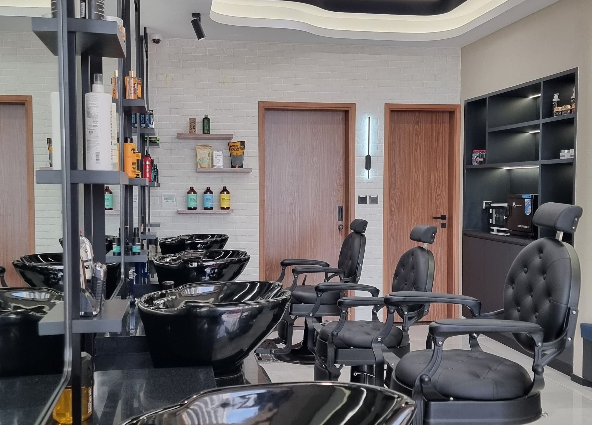 Modern barber chairs and wash stations at Pitstop Barbers, Dubai, AE, offering premium grooming services.