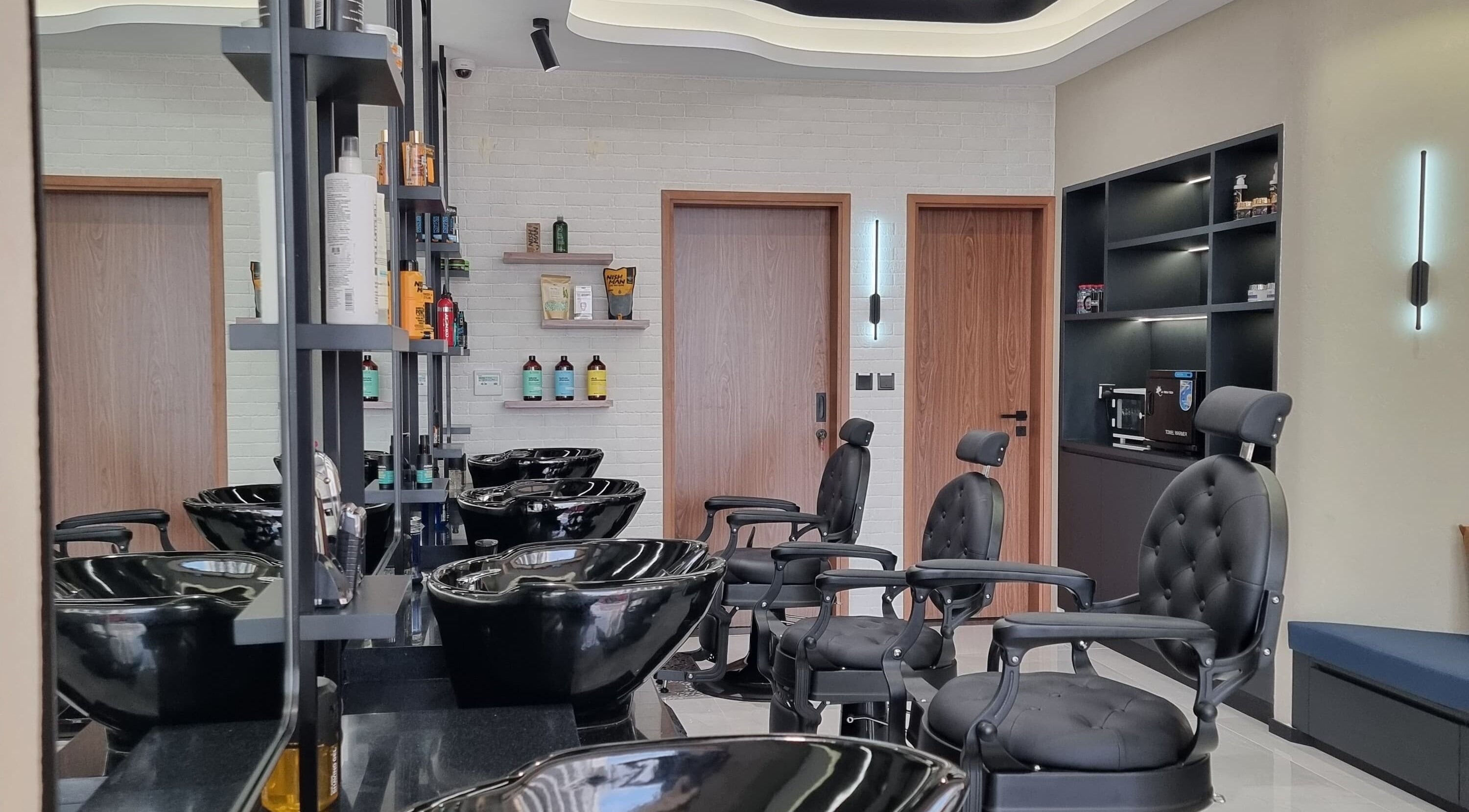 Modern barber chairs and wash stations at Pitstop Barbers, Dubai, AE, offering premium grooming services.
