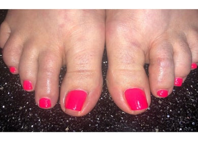 Vibrant neon pedicure at Bliss Home Beauty in Buntingford, England, GB on polished black surface.