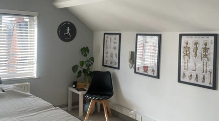 Calm therapy room at Peak Performance Clinic Heart of the Shires, Daventry, England, featuring anatomy charts.