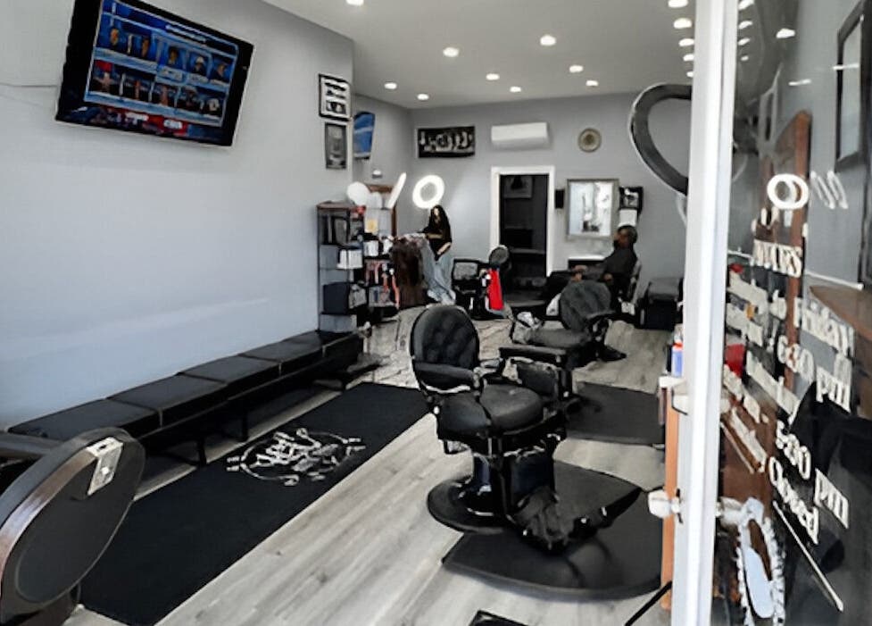 Interior of HC Shave House in Burbank, California, US, showcasing modern barber chairs and TV.
