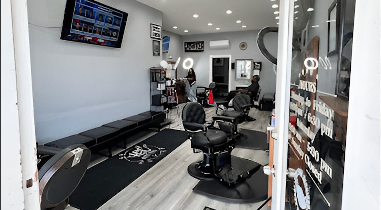 Interior of HC Shave House in Burbank, California, US, showcasing modern barber chairs and TV.