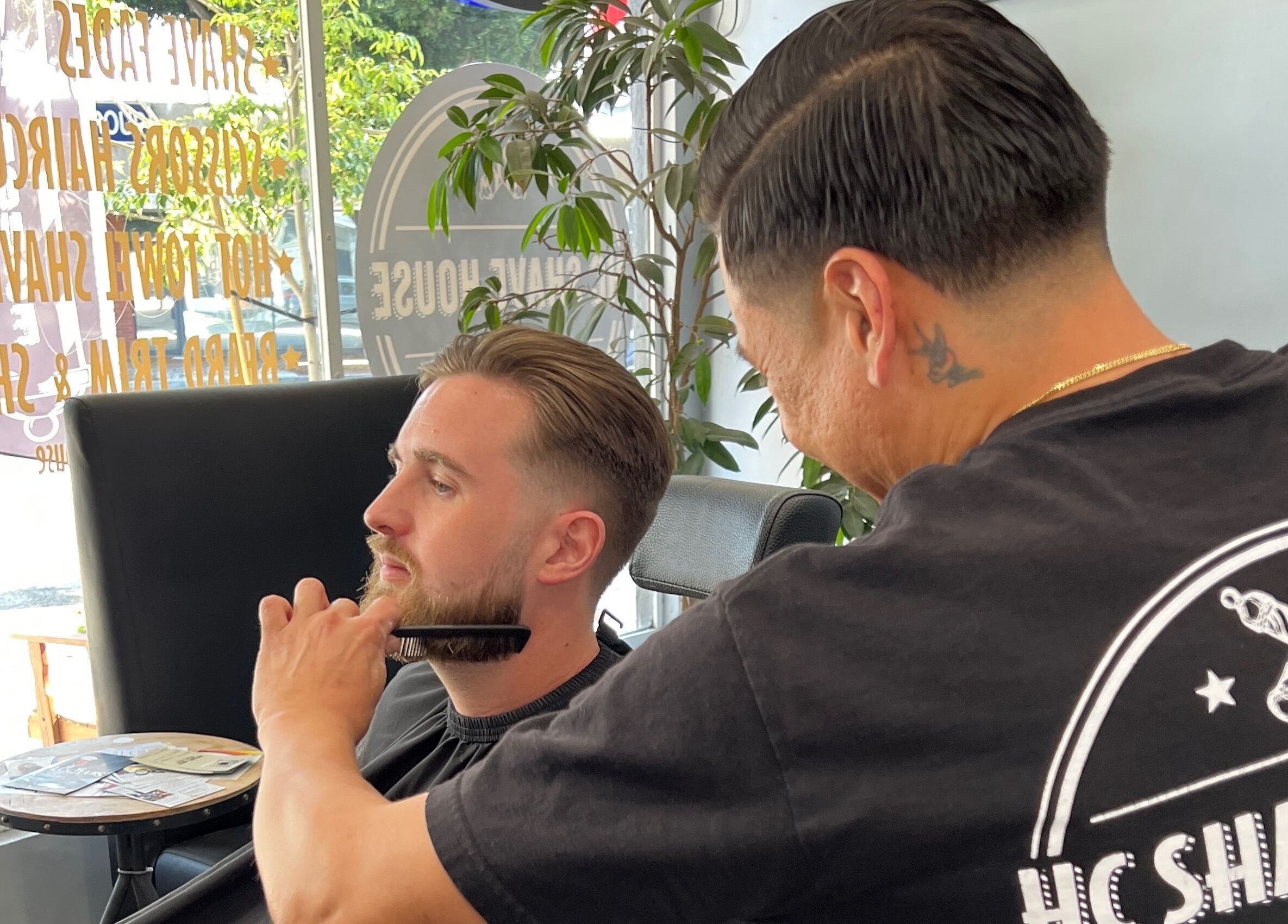 Barber trimming a beard at HC Shave House in Burbank, California, US, showcasing expert grooming.