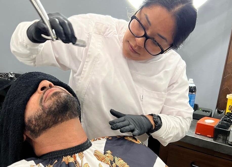 Barber providing premium shave service at HC Shave House in Burbank, California, US.