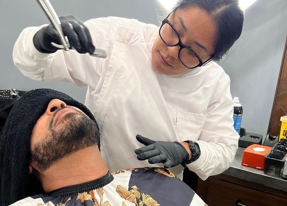 Barber providing premium shave service at HC Shave House in Burbank, California, US.