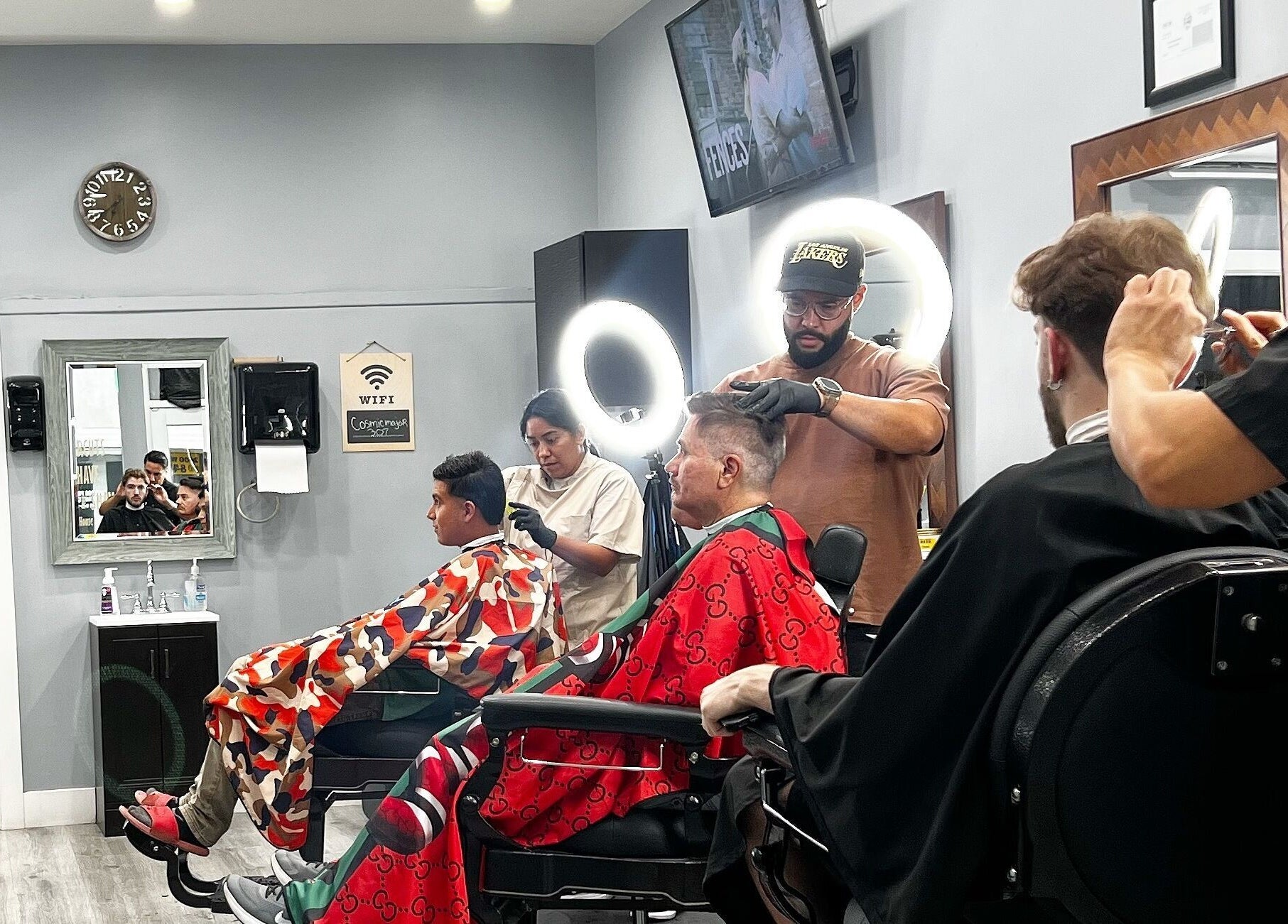 Barbers at HC Shave House in Burbank, California, US, expertly styling clients' hair under modern lighting.