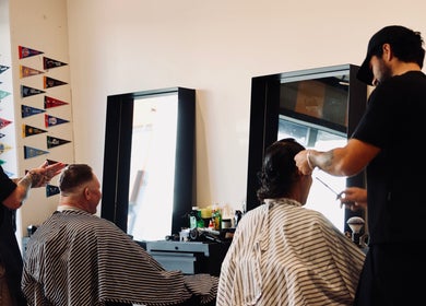 Barbers at Boar and Blade Ponsonby in Auckland, NZ, expertly styling clients' hair with precision.