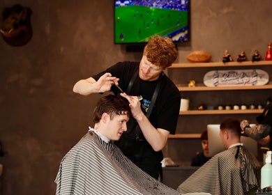 Barber crafting a stylish haircut at Boar and Blade Ponsonby, Auckland, Auckland, NZ.
