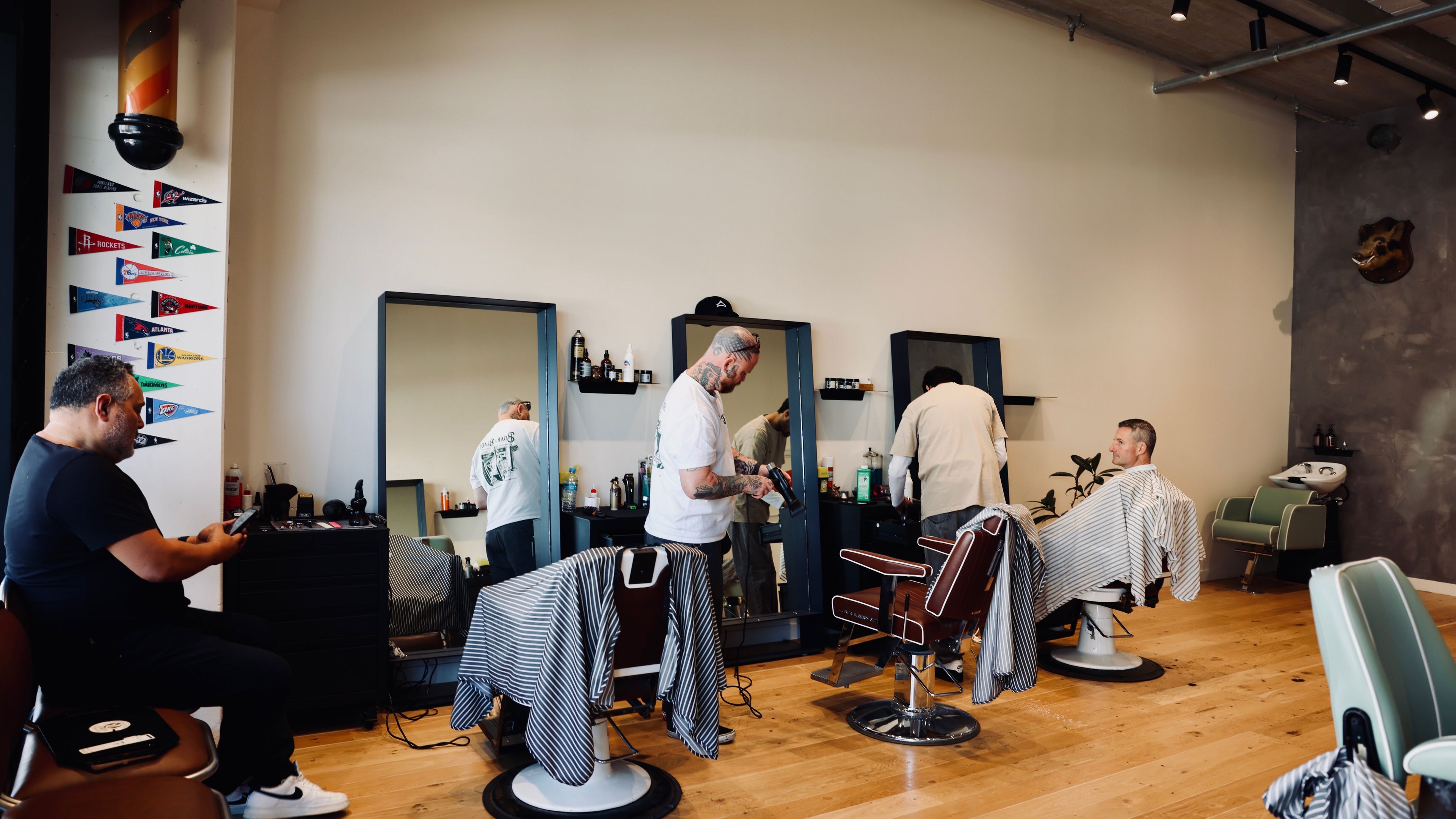Stylish barbershop interior at Boar and Blade Ponsonby, Auckland, Auckland, NZ with clients and barbers.