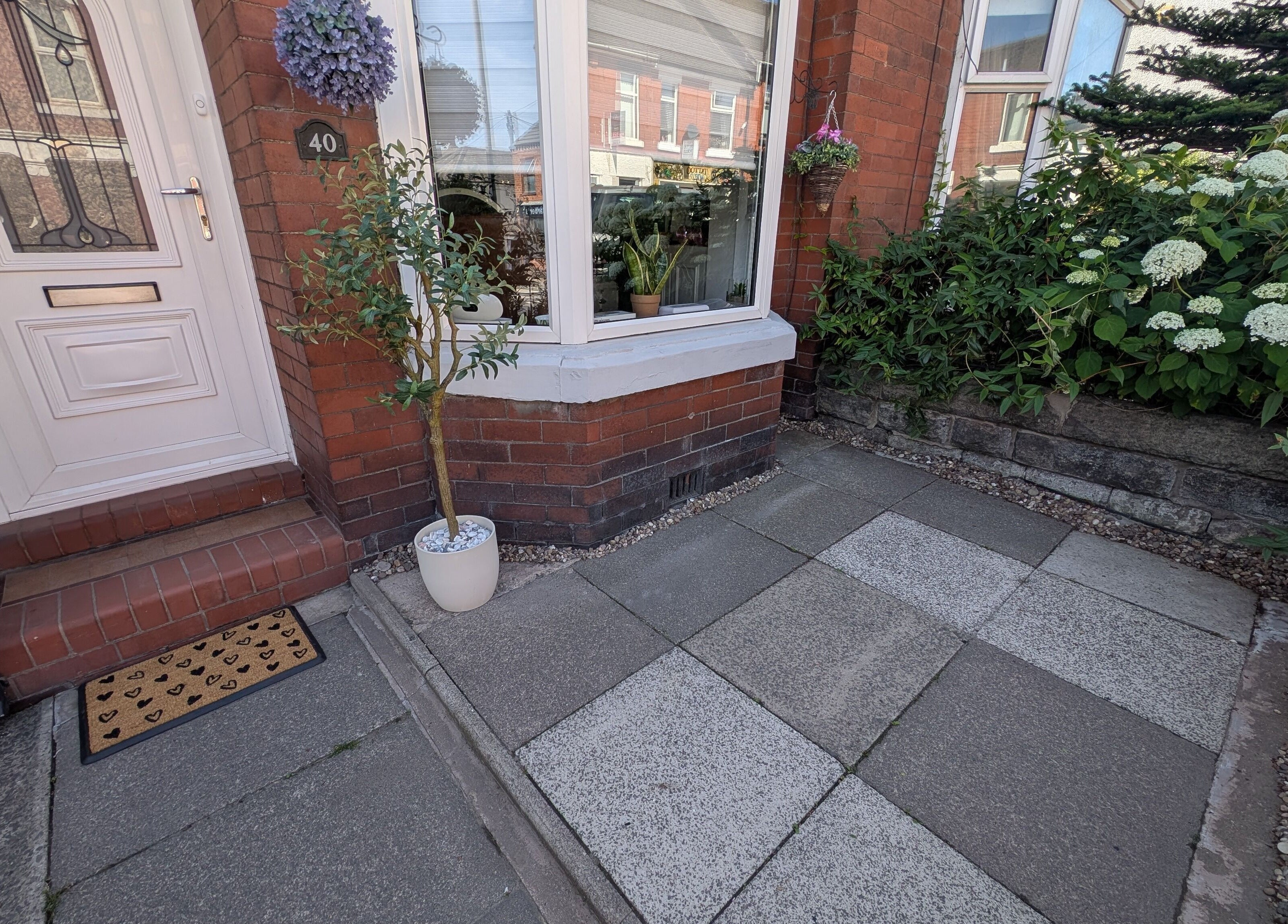 Welcoming entrance of Nails by Paula X in Biddulph, England, GB with potted plants and a decorative door.