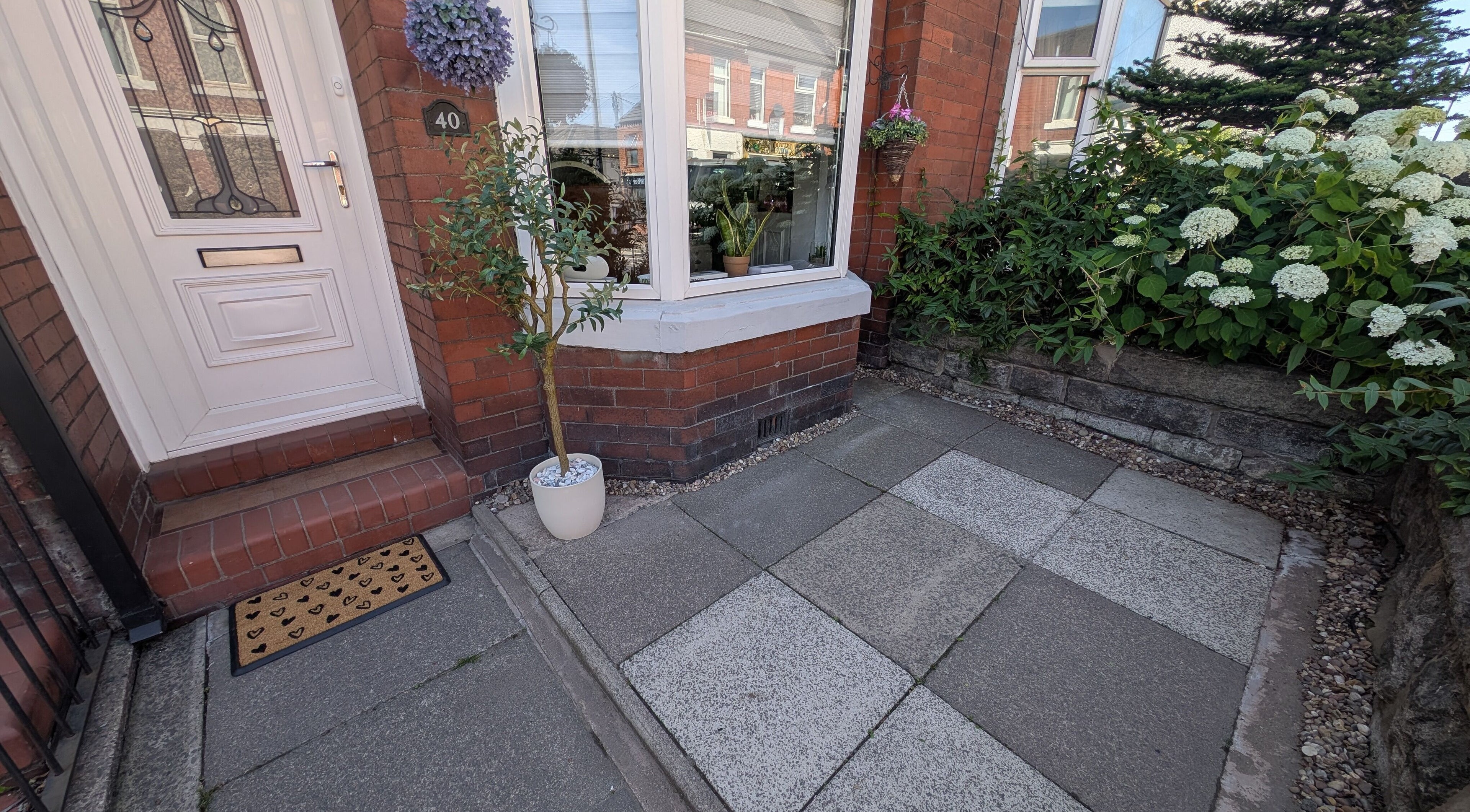 Welcoming entrance of Nails by Paula X in Biddulph, England, GB with potted plants and a decorative door.