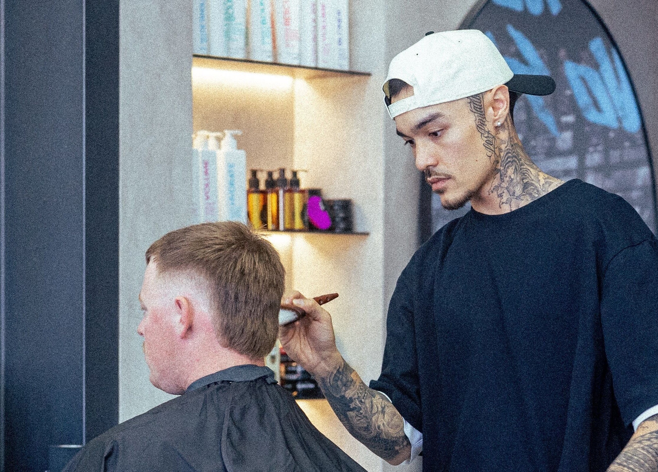 Barber at 1UP Barbershop Bicton styling a client's hair, in Bicton, Western Australia, AU.