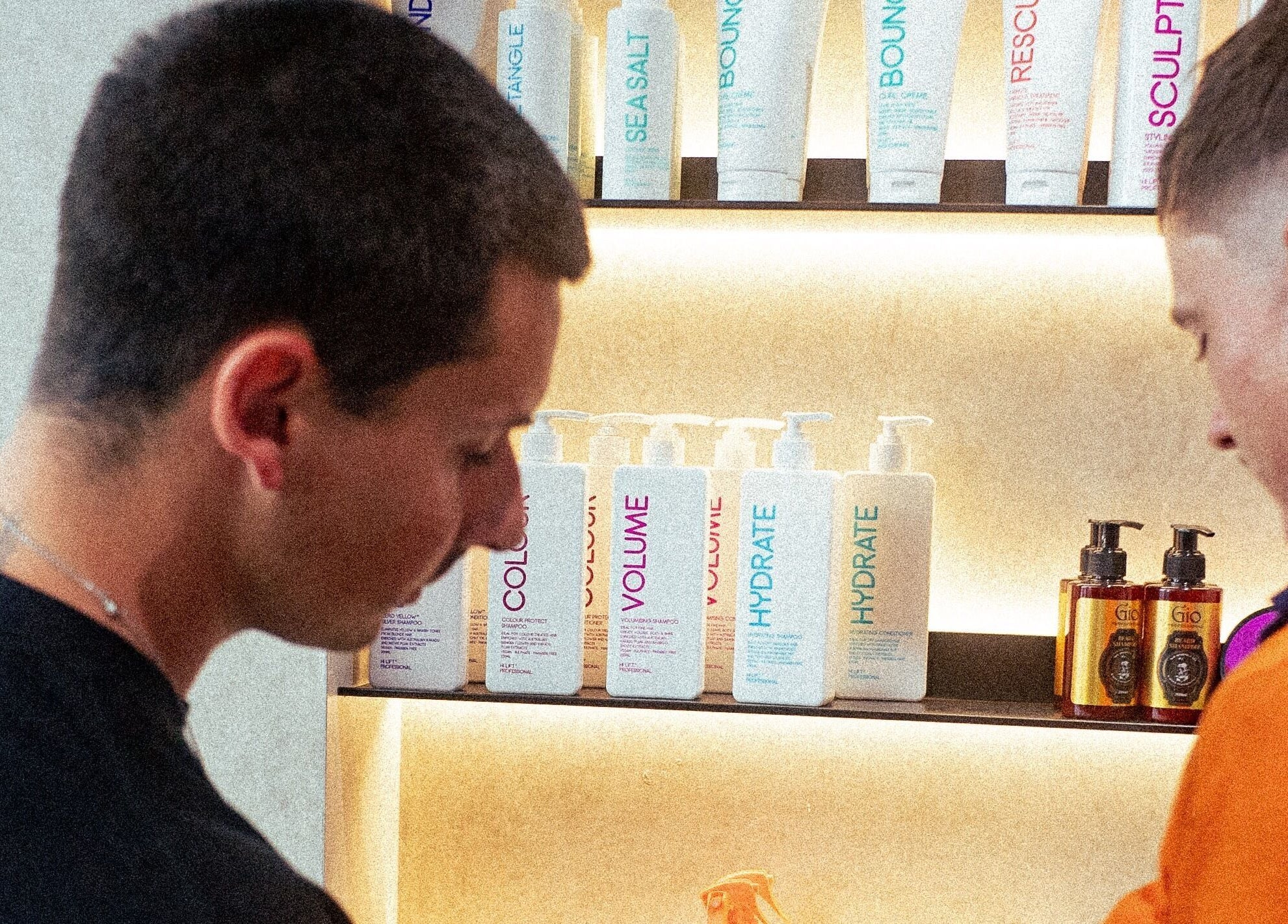 Stylists discussing hair products at 1UP Barbershop Bicton, Bicton, Western Australia, AU.