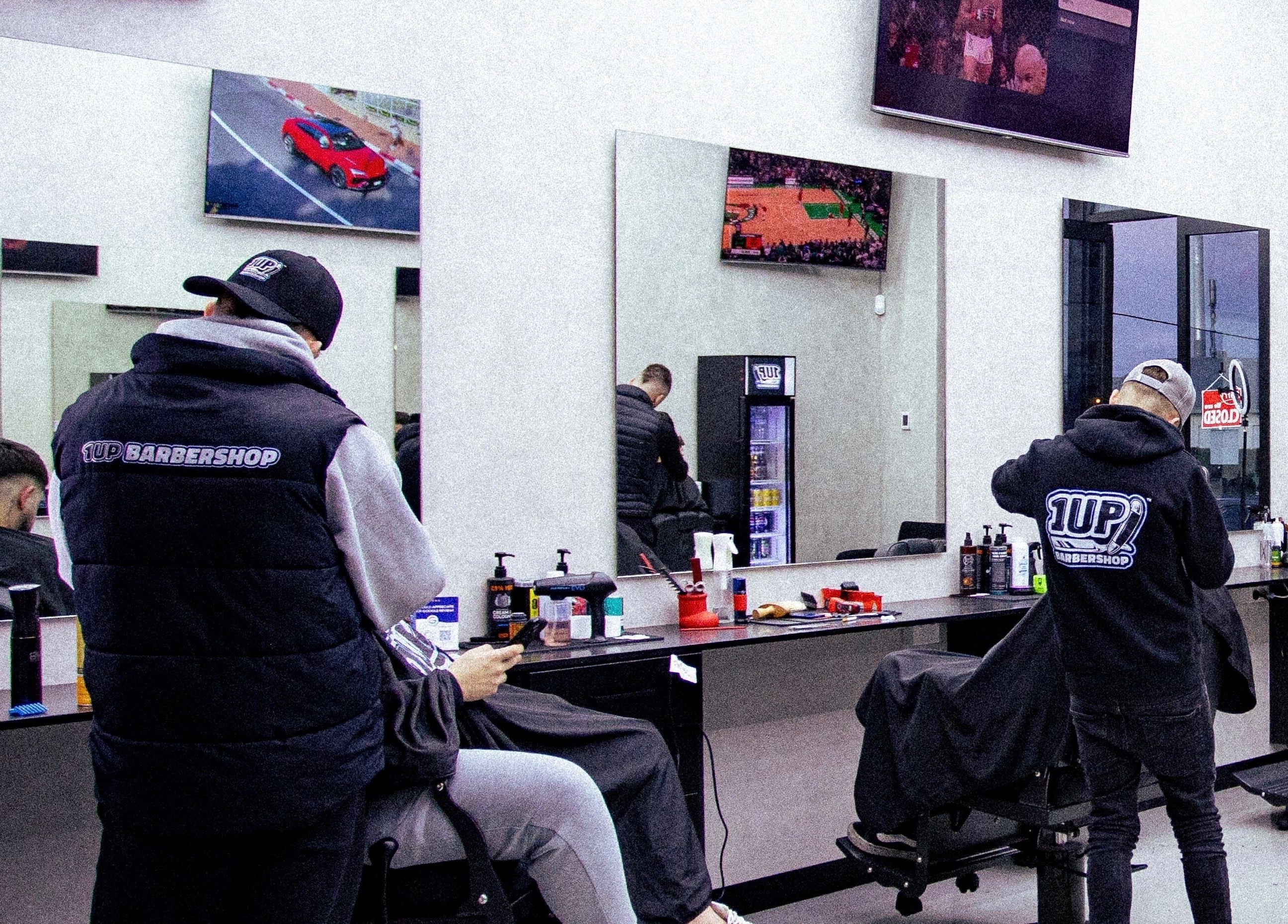 Modern interior of 1UP Barbershop Bicton in Bicton, Western Australia, AU, featuring skilled barbers at work.
