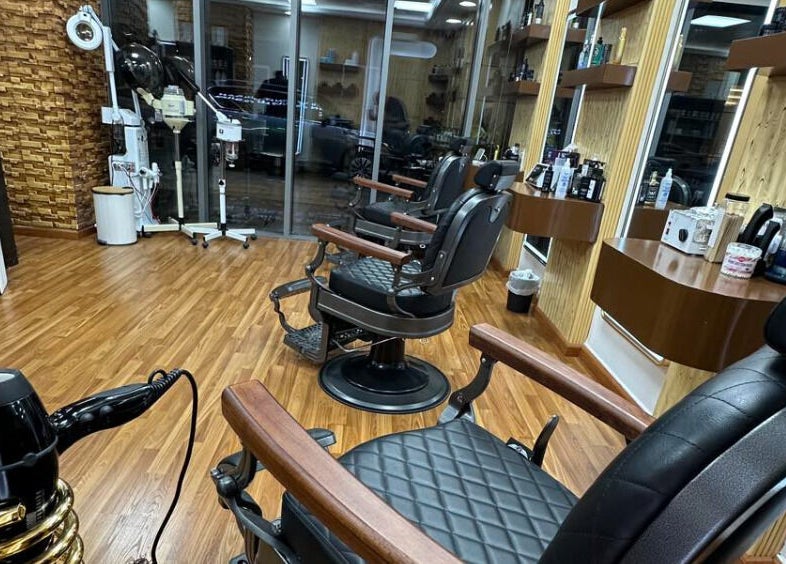 Modern barber chairs at Perfectly Trimmed Gents Salon, Abu Dhabi, Abu Dhabi, AE, showcasing sleek interior design.