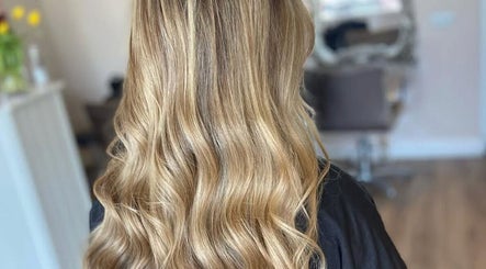 Golden wavy hairstyle at Gina Marks Hair in Elmswell, England, GB. Luxurious salon interior in background.