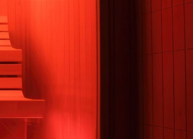 Warm red-lit sauna at CoalitionSkin | Holistic Spa Downtown Vancouver, offering relaxation in Vancouver, British Columbia, CA.