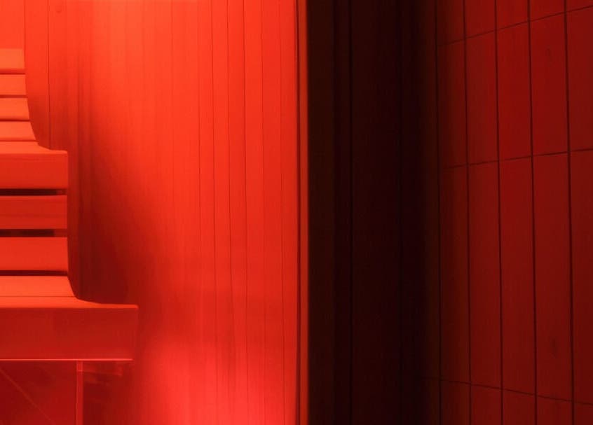 Warm red-lit sauna at CoalitionSkin | Holistic Spa Downtown Vancouver, offering relaxation in Vancouver, British Columbia, CA.