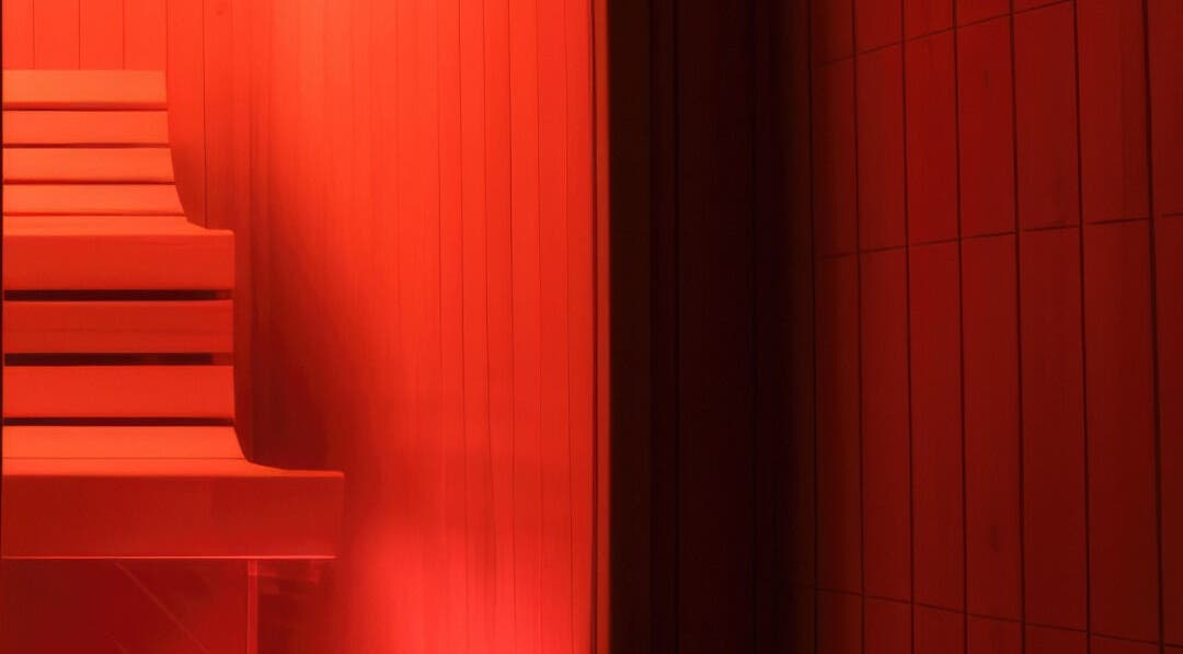 Warm red-lit sauna at CoalitionSkin | Holistic Spa Downtown Vancouver, offering relaxation in Vancouver, British Columbia, CA.