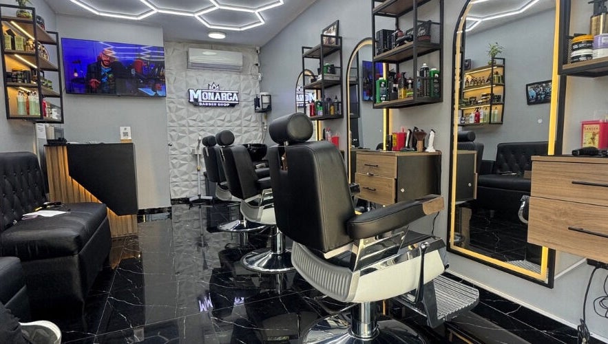 Interior moderno de Monarca Barberia - Miraflores en LIMA, Provincia De Lima, PE, mostrando sillas y espejos elegantes.