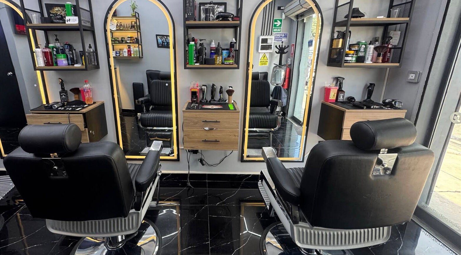 Interior moderno de Monarca Barberia - Miraflores en LIMA, Provincia De Lima, PE con sillas y espejos iluminados.