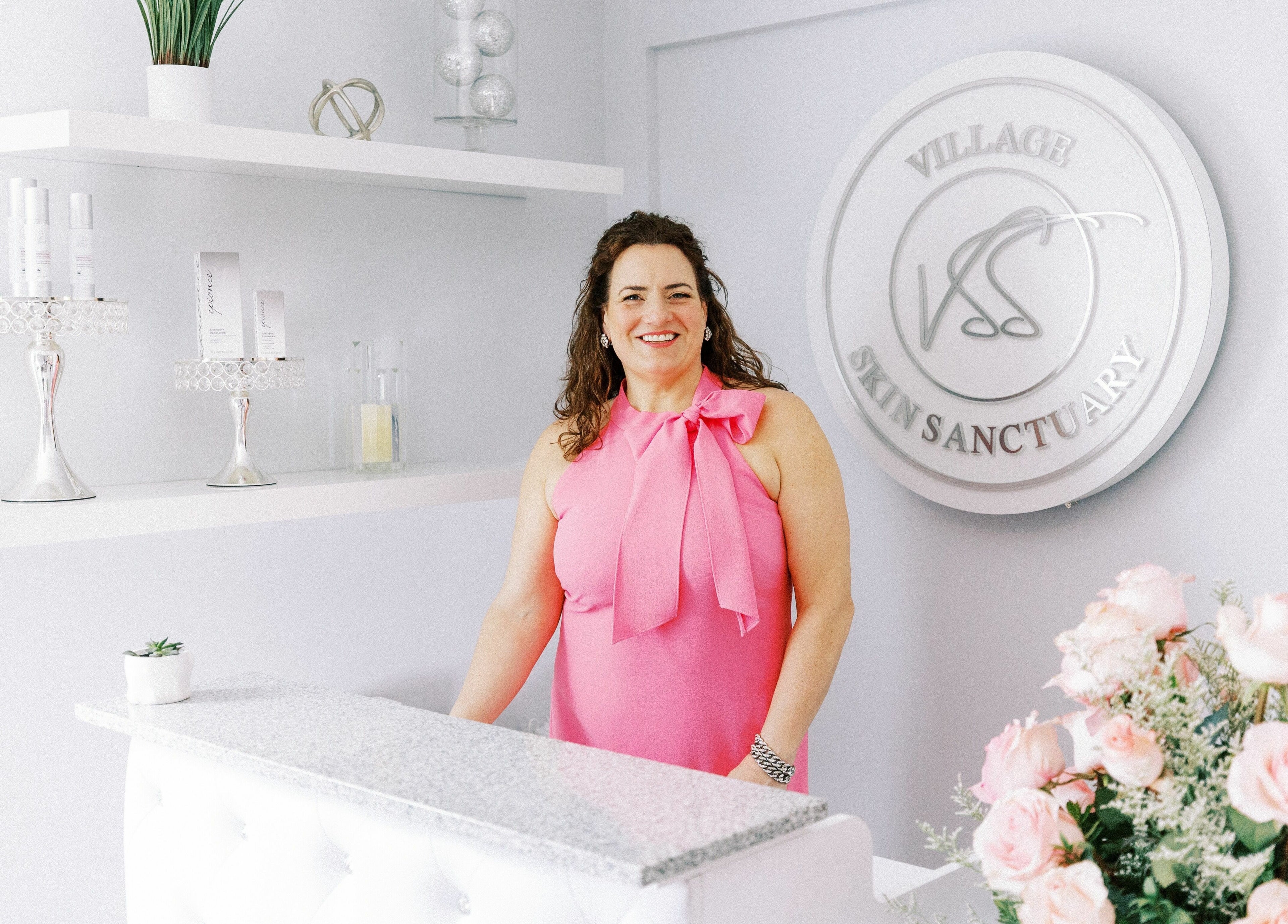 A welcoming staff member at Village Skin Sanctuary, Audubon, Pennsylvania, US with elegant interior decor.