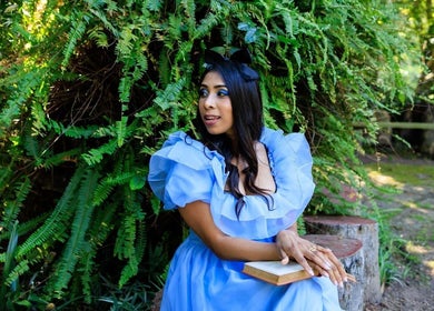 Woman in blue dress sitting amidst greenery at Black Cat Collective, Port Elizabeth, Eastern Cape, ZA.
