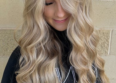 Gloss Creations in Wallerawang, NSW, AU showcases stunning blonde waves on a smiling client.