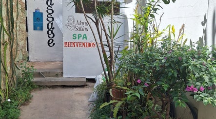 Entrada al Spa María Sabina en Oaxaca De Juárez, Oaxaca, MX, rodeada de plantas verdes.