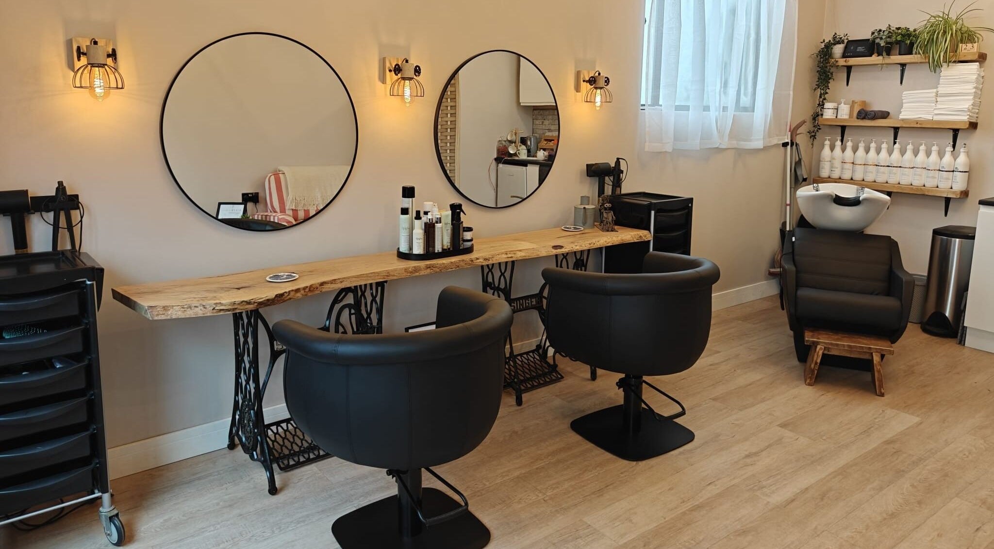 Trendy salon interior at Hair by Lauren in Ipswich, England, GB with modern styling chairs and washbasin.