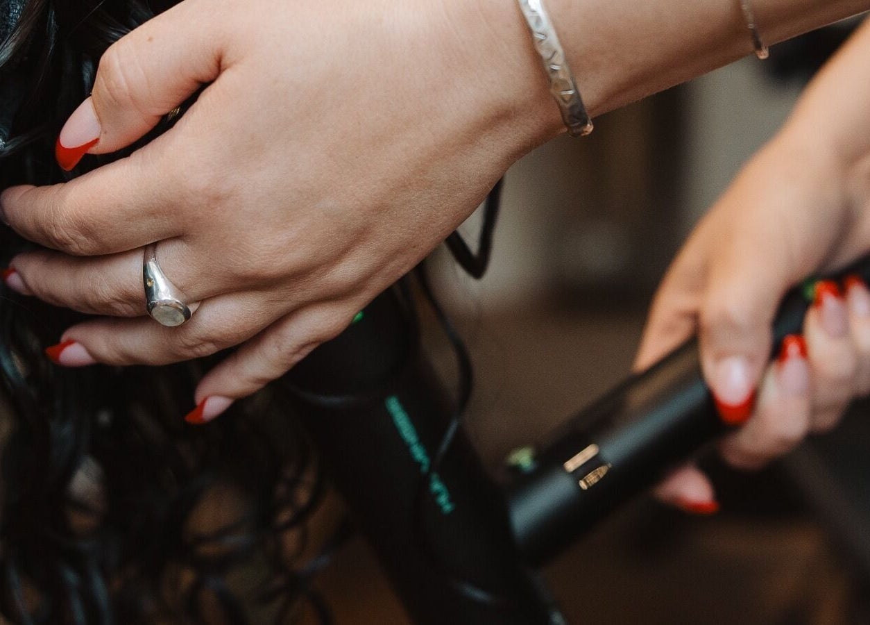 Stylist curling hair at Naomi Cuts Curls, Kelowna, British Columbia, CA with precision and care.