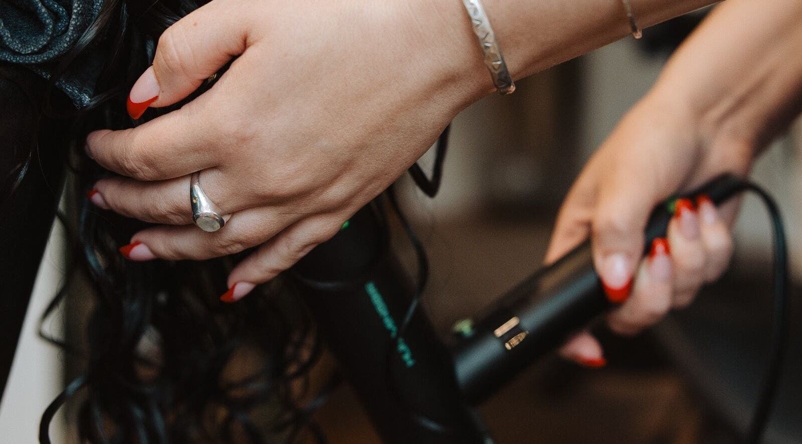 Stylist curling hair at Naomi Cuts Curls, Kelowna, British Columbia, CA with precision and care.