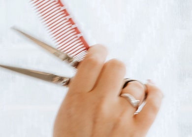 Hand holding scissors and comb at Naomi Cuts Curls, Kelowna, British Columbia, CA.